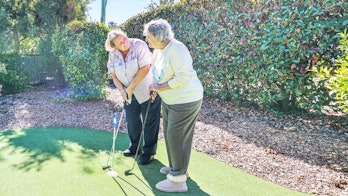 Bupa team with resident on mini golf course