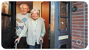 A friendly elderly couple answering the door to their Support Worker